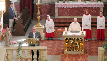 Blick von der Empore hinunter in die Kirche. Links am Ambo ist der Redner. Am Altar steht der Pfarrer.